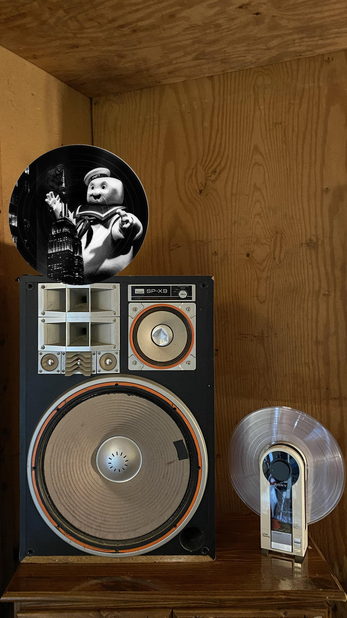 Circular vinyl record wall art of King Kong and Stay Puft Marshmallow Man at the Empire State Building, displayed in a music room.