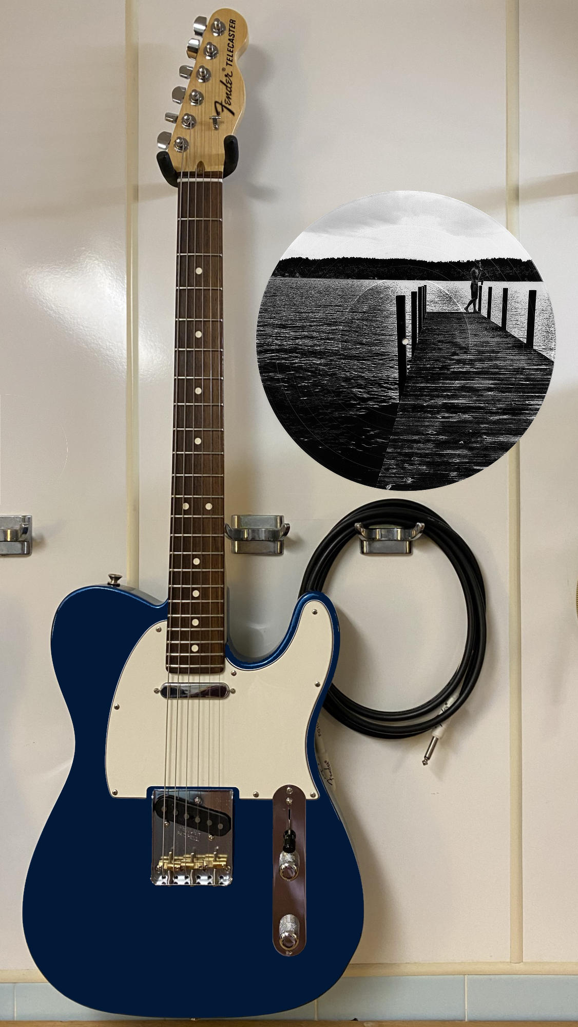 Black and white vinyl record photo art of a person on a dock at sunrise, featured in a recording studio setting.